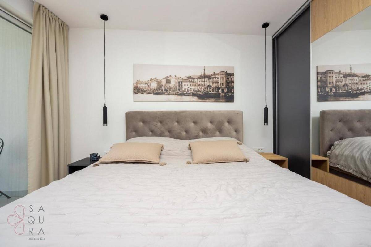 Modernes Schlafzimmer mit großem Doppelbett, Nachttischen und eleganten Einbauschränken.