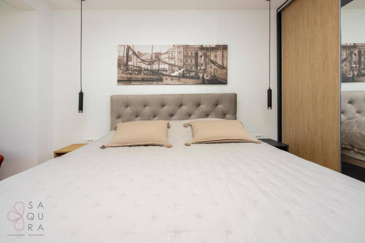 Komfortables Schlafzimmer mit großem Bett, Nachttischen und eleganten Einbauschränken.