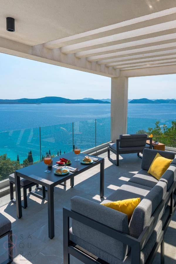 Geräumige Terrasse mit modernen Lounge-Möbeln und Esstisch, bietet einen weiten Meerblick.