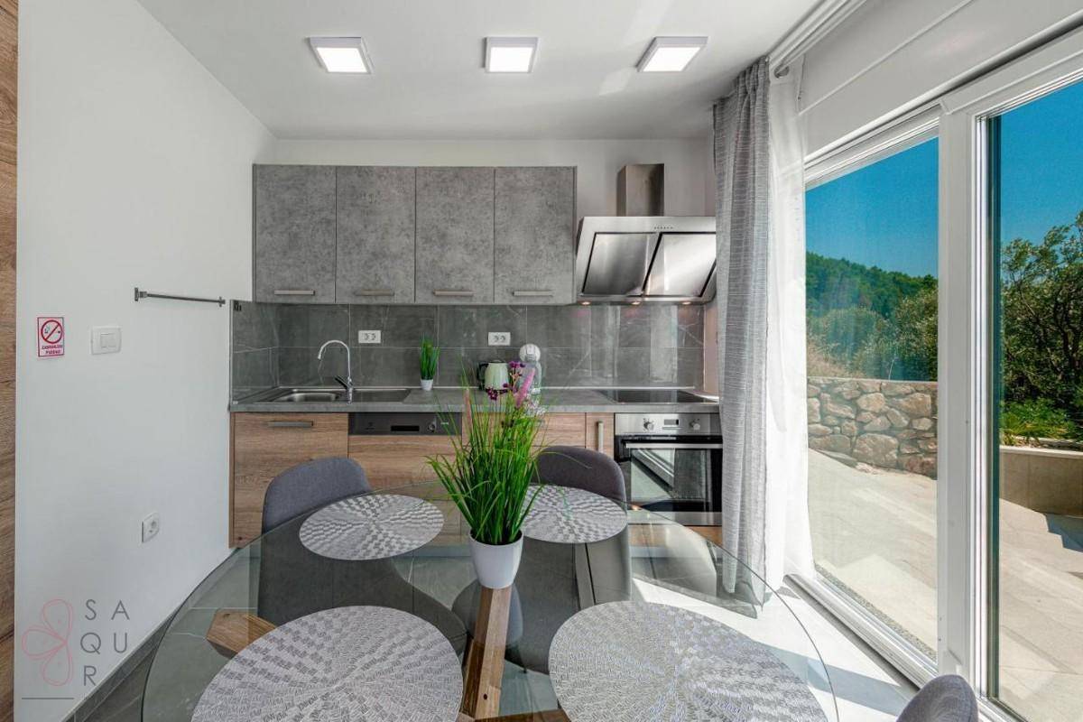 Moderne Küche mit Essbereich und Zugang zur Terrasse, ausgestattet mit zeitgemäßen Geräten.