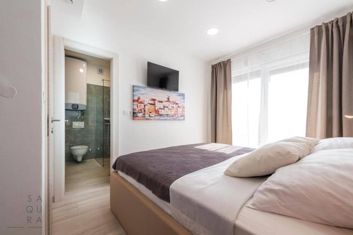 Gemütliches Schlafzimmer mit Doppelbett und direktem Zugang zu einem modernen Badezimmer.