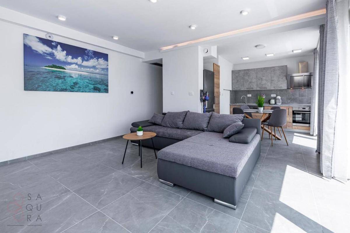 Geräumiger offener Wohnbereich mit Sofa, Essbereich und moderner Küche, hell und einladend.