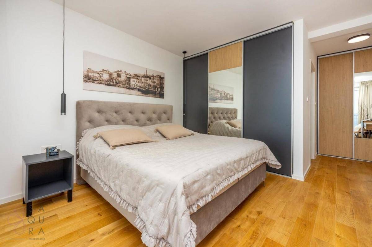 Gemütliches Schlafzimmer mit großem Bett, Nachttischen und modernen Einbauschränken mit Spiegelfronten.