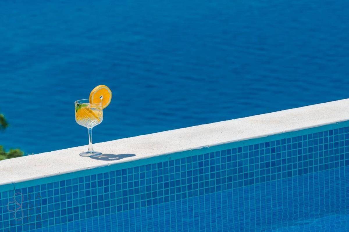 Erfrischendes Getränk am Poolrand mit dem tiefblauen Meer im Hintergrund.