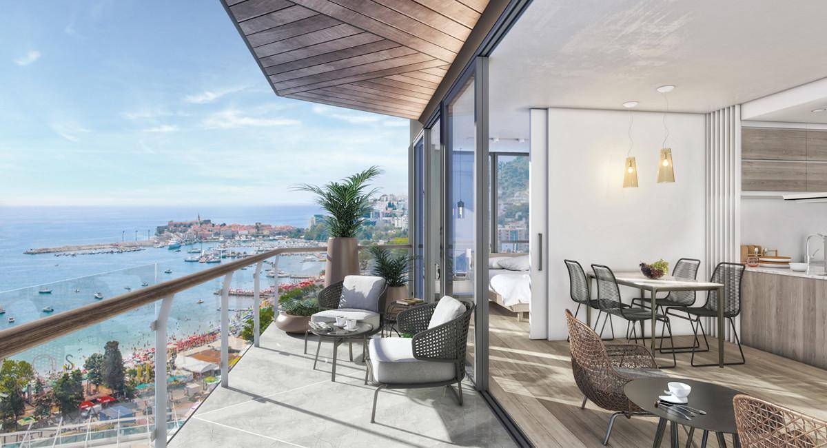 Heller Wohnbereich mit Zugang zu einem Balkon, der einen weiten Blick auf das Meer und die Stadt bietet.