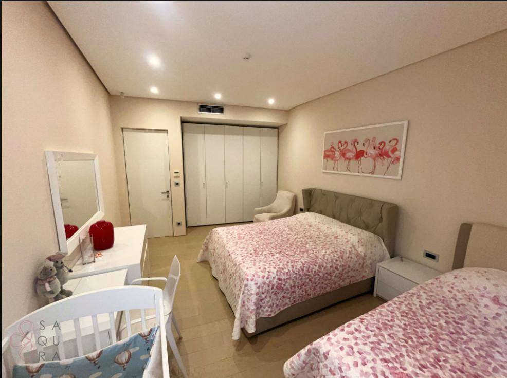 Gemütliches Schlafzimmer mit zwei Betten, Einbauschränken und moderner Dekoration.