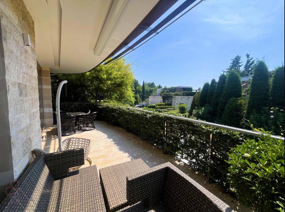 Großer Balkon mit bequemen Loungemöbeln und Blick auf die üppige grüne Umgebung, ideal zum Entspannen.