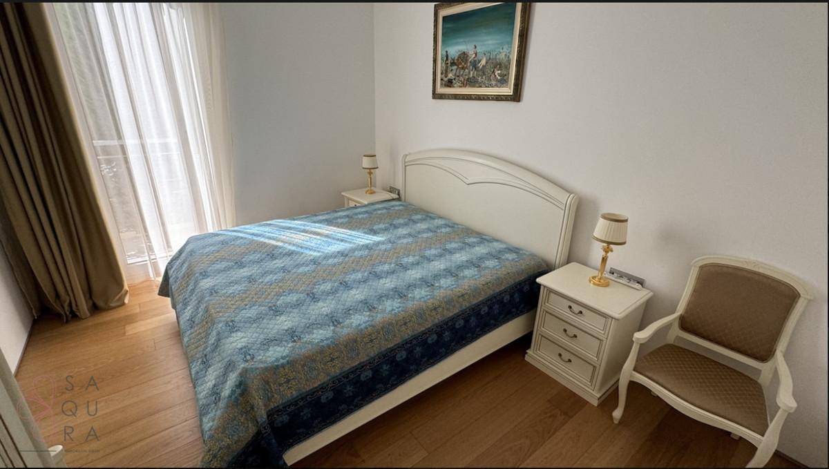 Gemütliches Schlafzimmer mit Doppelbett, Nachttischen und hellem Parkettboden.