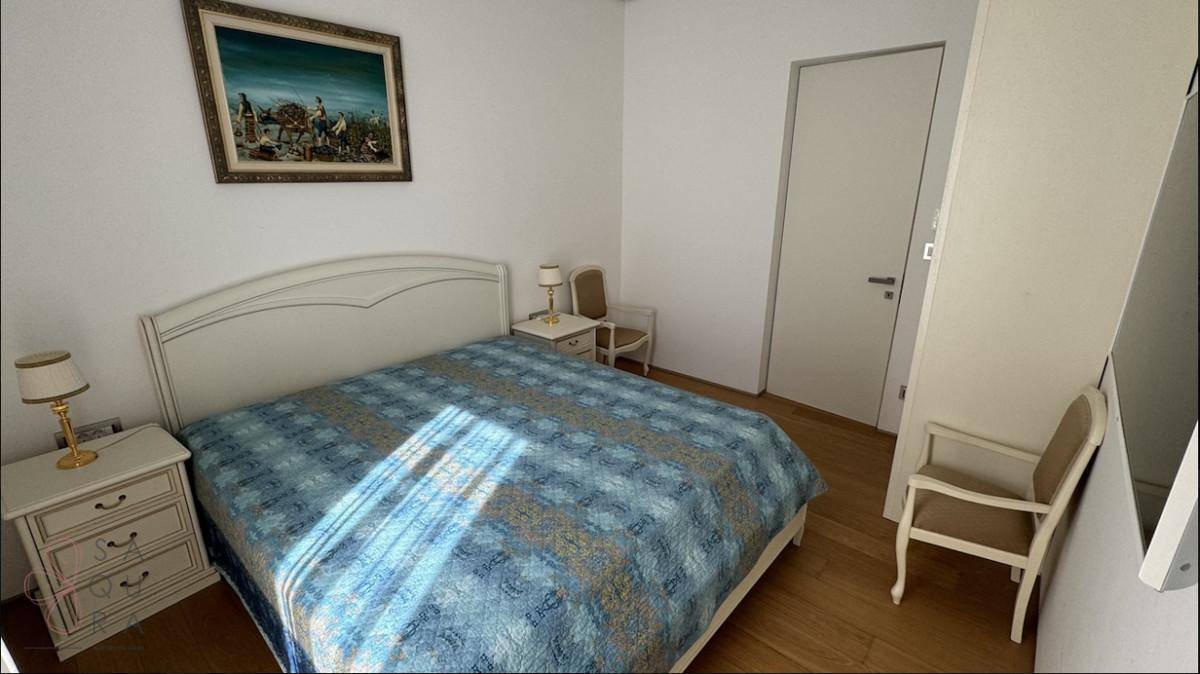 Helles Schlafzimmer mit Doppelbett, Nachttischen und klassischem Gemälde an der Wand.