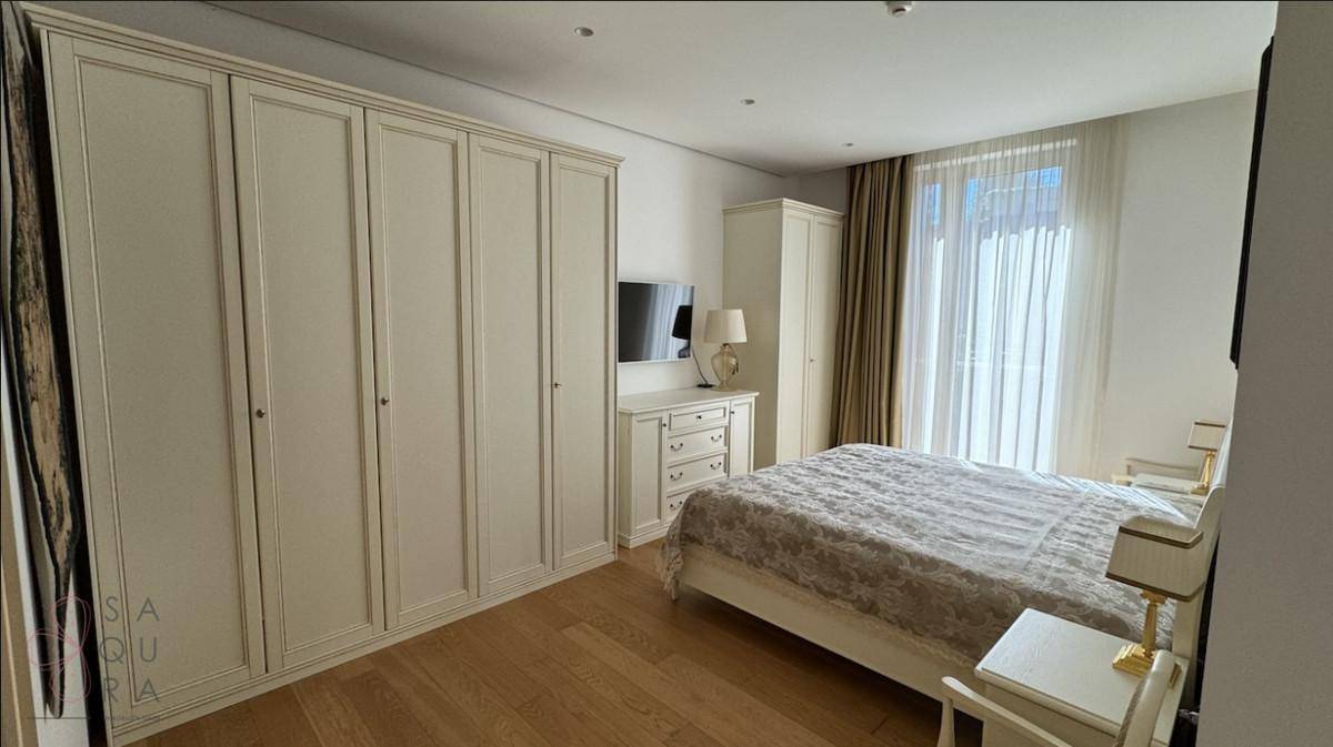 Geräumiges Schlafzimmer mit großen Einbauschränken, Doppelbett und hellem Parkettboden.