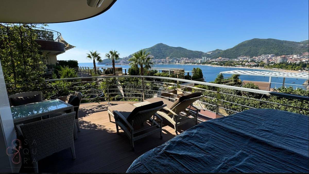 Großer Balkon mit Meerblick, Sonnenliegen und Esstisch, ideal zum Entspannen im Freien.