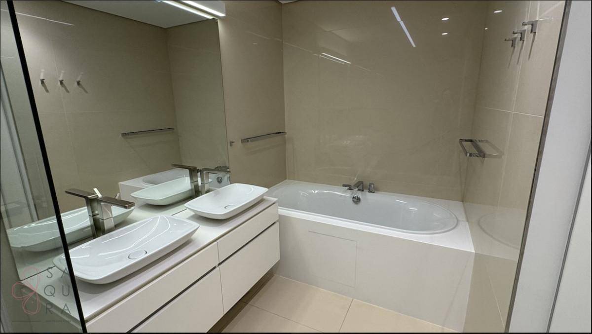 Elegantes Badezimmer mit Badewanne, Doppelwaschbecken und großem Spiegel in neutralen Farbtönen.