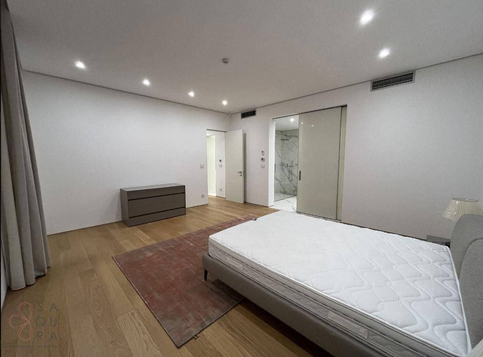 Geräumiges Schlafzimmer mit Holzboden und Zugang zu einem eleganten Badezimmer, ideal für Komfort.