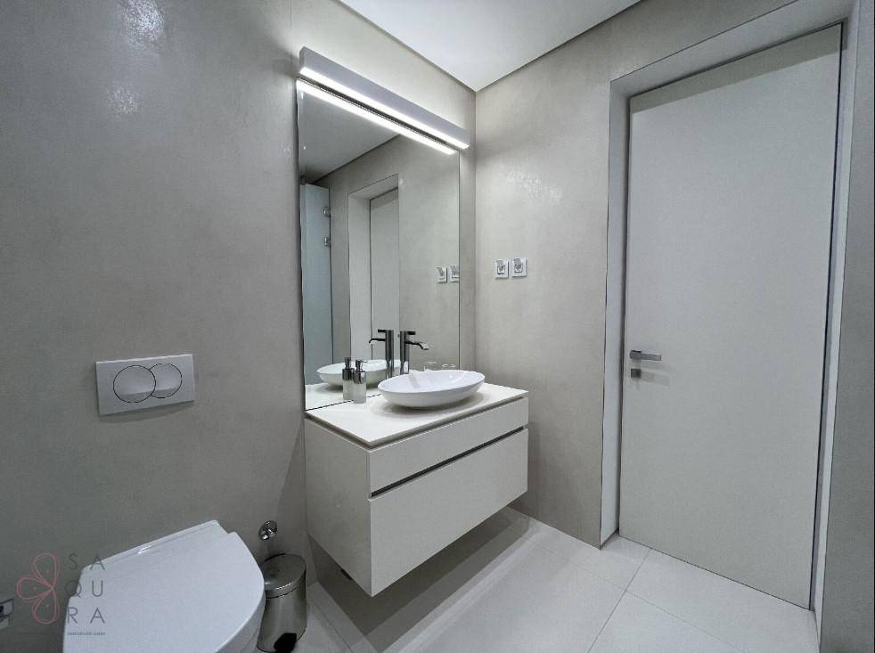 Elegantes Badezimmer mit modernem Waschtisch, Wand-WC und großem Spiegel, in schlichtem Design.