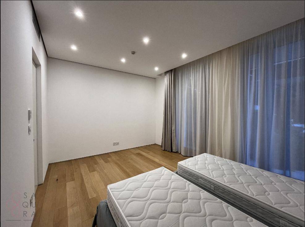 Geräumiges Schlafzimmer mit Holzboden und großen Fenstern, bereit für individuelle Einrichtung.