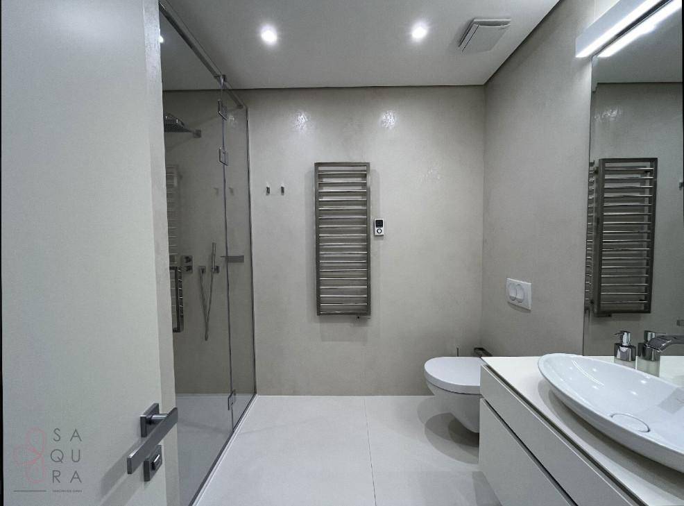 Modernes Badezimmer mit begehbarer Dusche, Wand-WC und beheiztem Handtuchhalter, in elegantem Design.