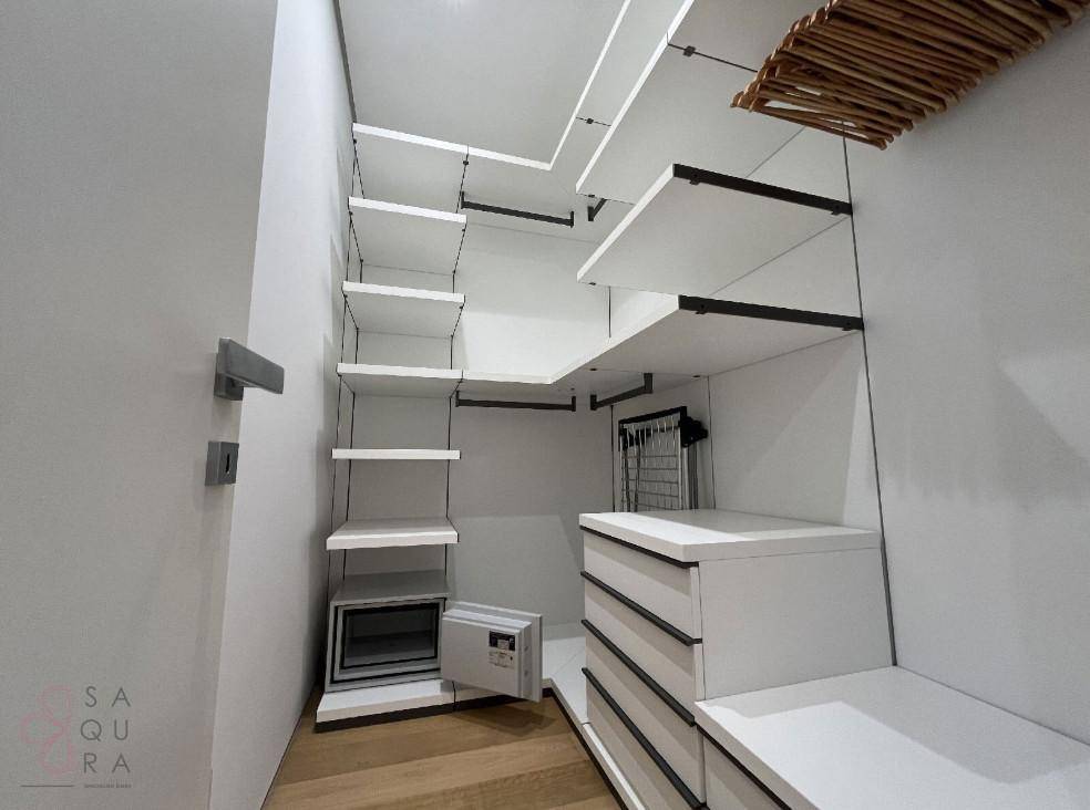 Gut organisierter begehbarer Kleiderschrank mit Regalen, Schubladen und integriertem Safe.