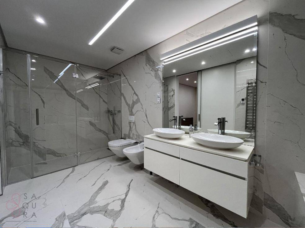 Elegantes Badezimmer mit Marmorfliesen, Doppelwaschbecken, Bidet und geräumiger begehbarer Dusche.
