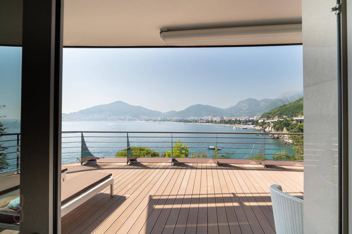 Terrasse mit weitem Meerblick, Holzdeck und Zugang zum Innenbereich.