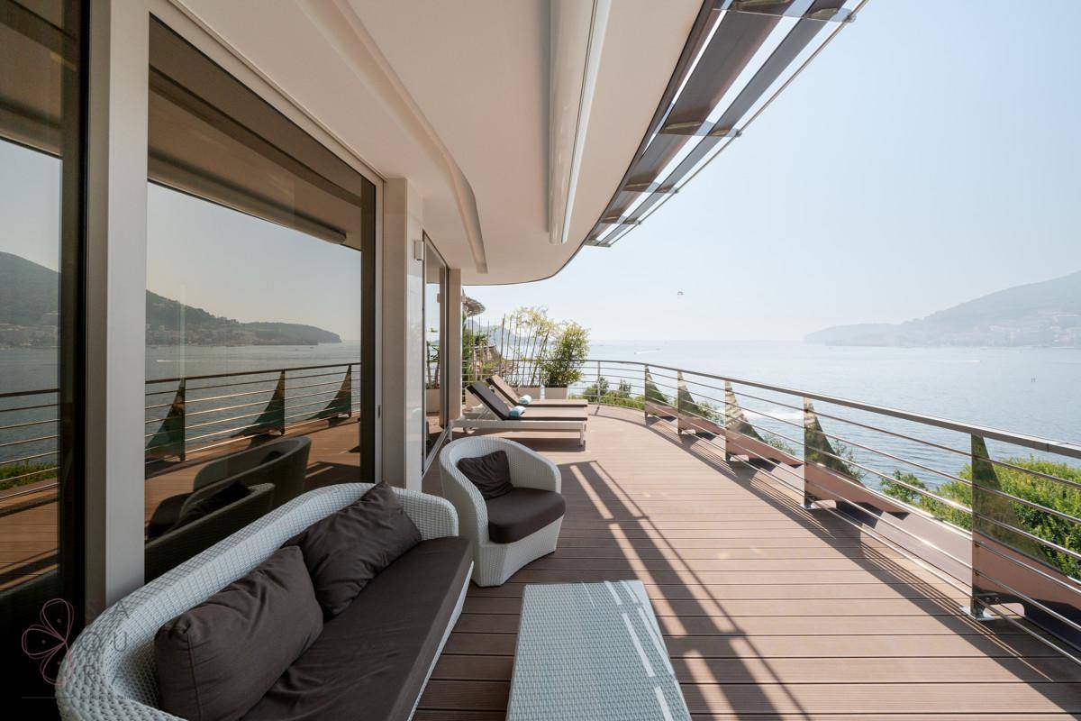 Große Terrasse mit Meerblick, Loungemöbeln und Holzdeck.