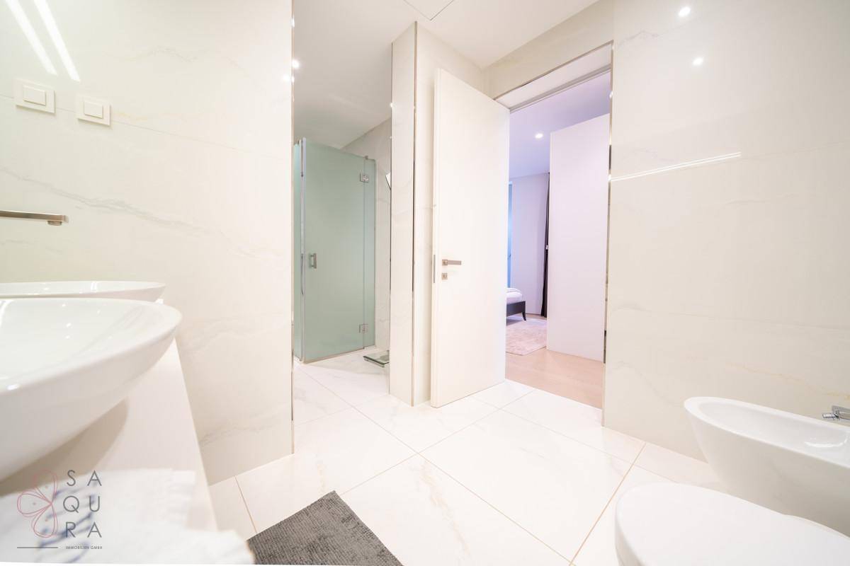 Helles Badezimmer mit Bidet, Toilette und Duschkabine.