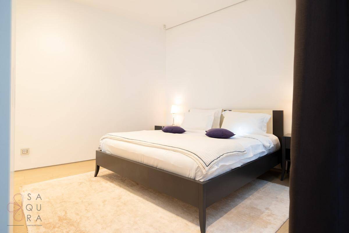 Schlafzimmer mit Doppelbett, Nachttischen und Teppichboden.