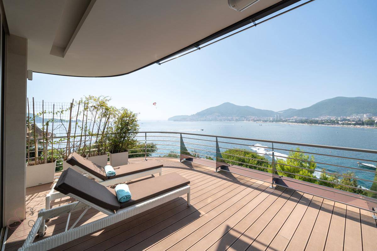 Geräumige Terrasse mit Liegestühlen und Panoramablick auf das Meer und die Küste.