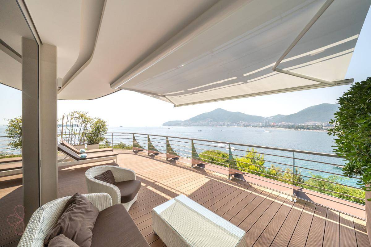 Große Terrasse mit ausfahrbarer Markise, Loungemöbeln und atemberaubendem Meerblick.
