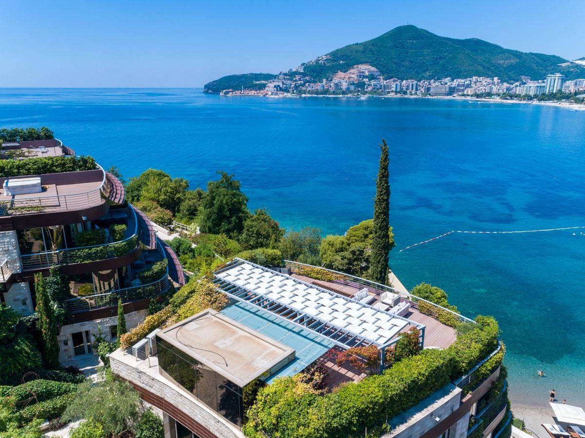 Dachterrasse mit Pergola und üppiger Bepflanzung, bietet einen weiten Blick auf das Meer und die Stadt.