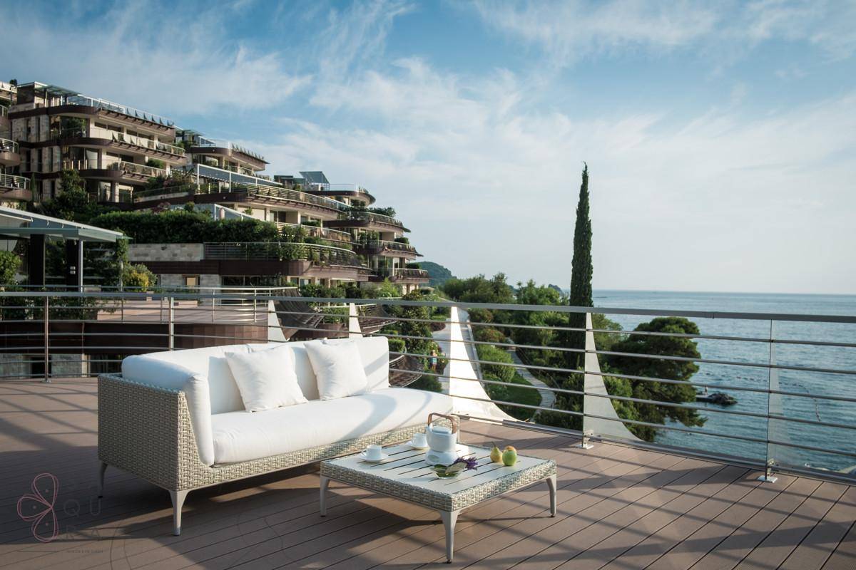 Eine stilvolle Terrasse mit bequemen Outdoor-Möbeln und einem atemberaubenden Panoramablick auf das Meer.