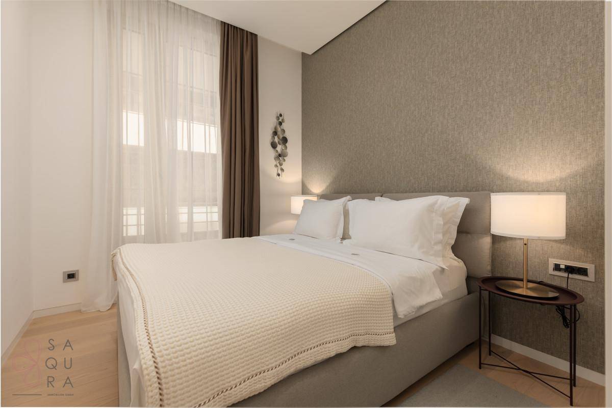 Ein gemütliches Schlafzimmer mit Doppelbett, Nachttischen und indirekter Beleuchtung, in warmen Farbtönen gehalten.