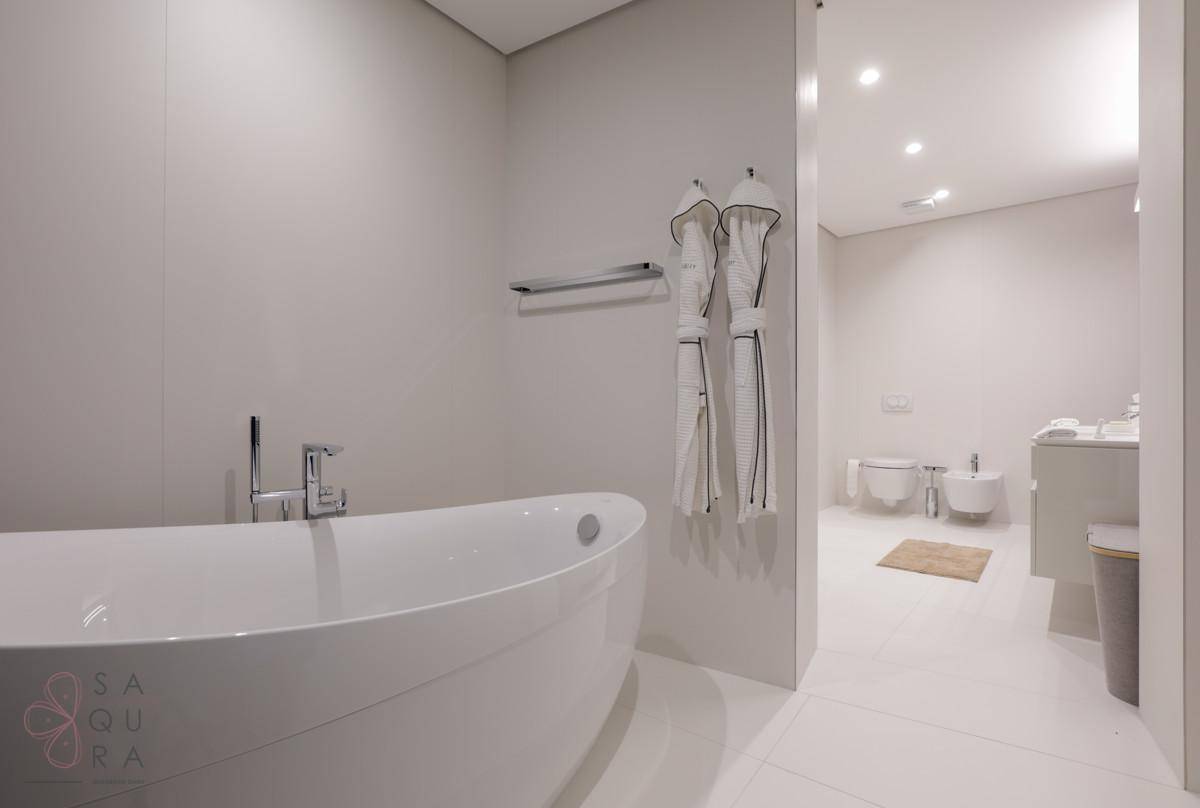 Helles Badezimmer mit freistehender Badewanne und minimalistischem Design, das einen weiteren Bereich zeigt.
