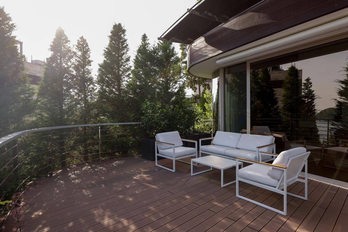 Geräumige Sonnenterrasse mit modernen Outdoor-Möbeln und üppiger Bepflanzung.