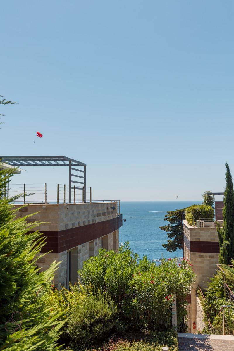 Atemberaubender Meerblick von einer modernen Dachterrasse mit Pergola und üppiger Vegetation, ideal zum Entspannen.