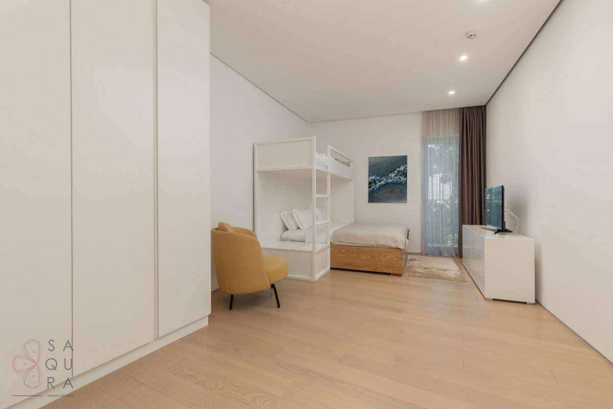 Geräumiges Schlafzimmer mit Etagenbett, Einzelbett und hellem Holzfußboden, ideal für Kinder oder Gäste.