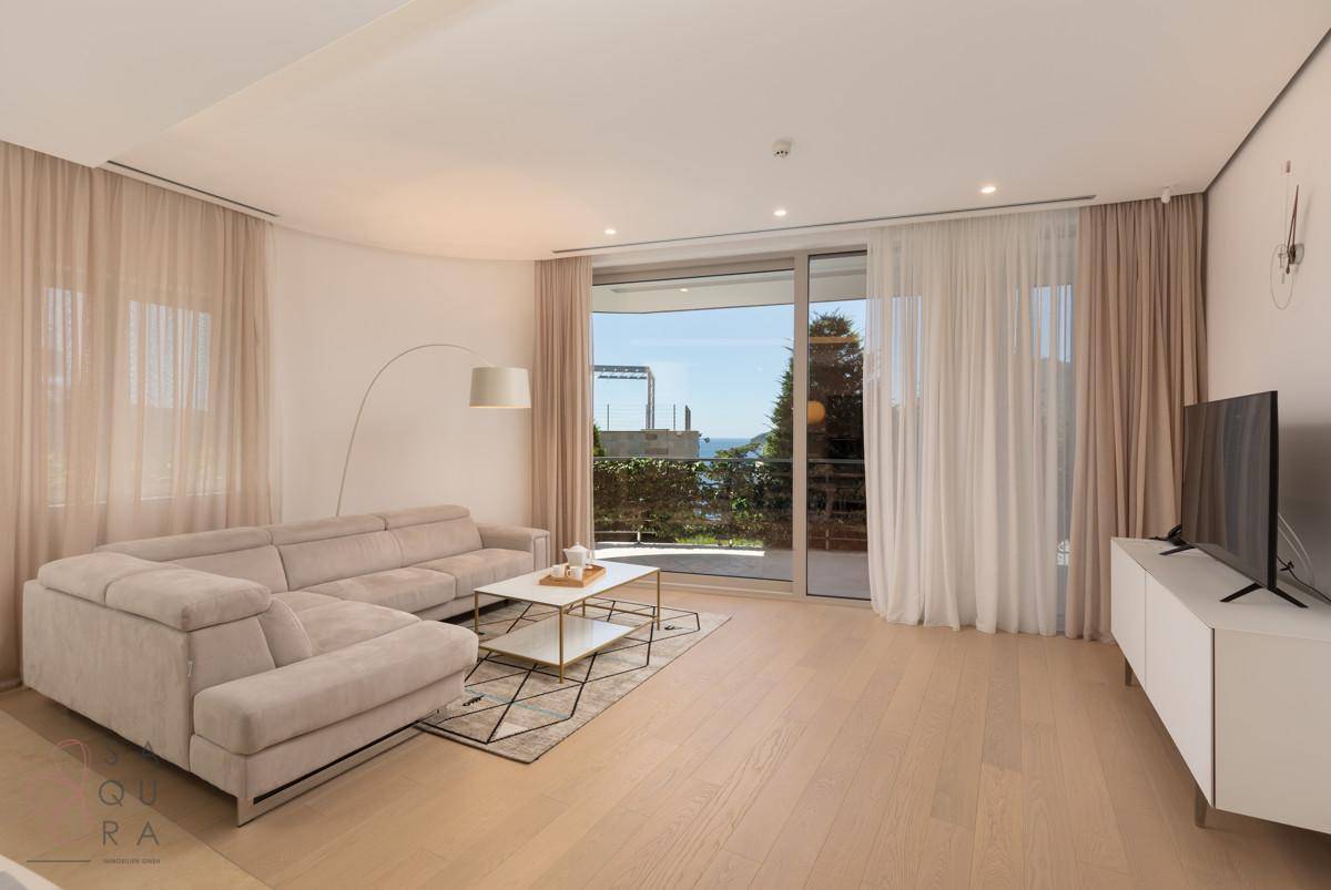 Geräumiges Wohnzimmer mit Zugang zum Balkon und hellem Holzfußboden.