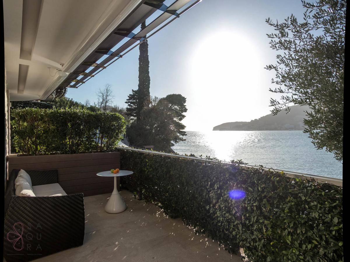 Gemütliche Terrasse mit Sitzgelegenheiten und einem weiten Blick über das glitzernde Meer.