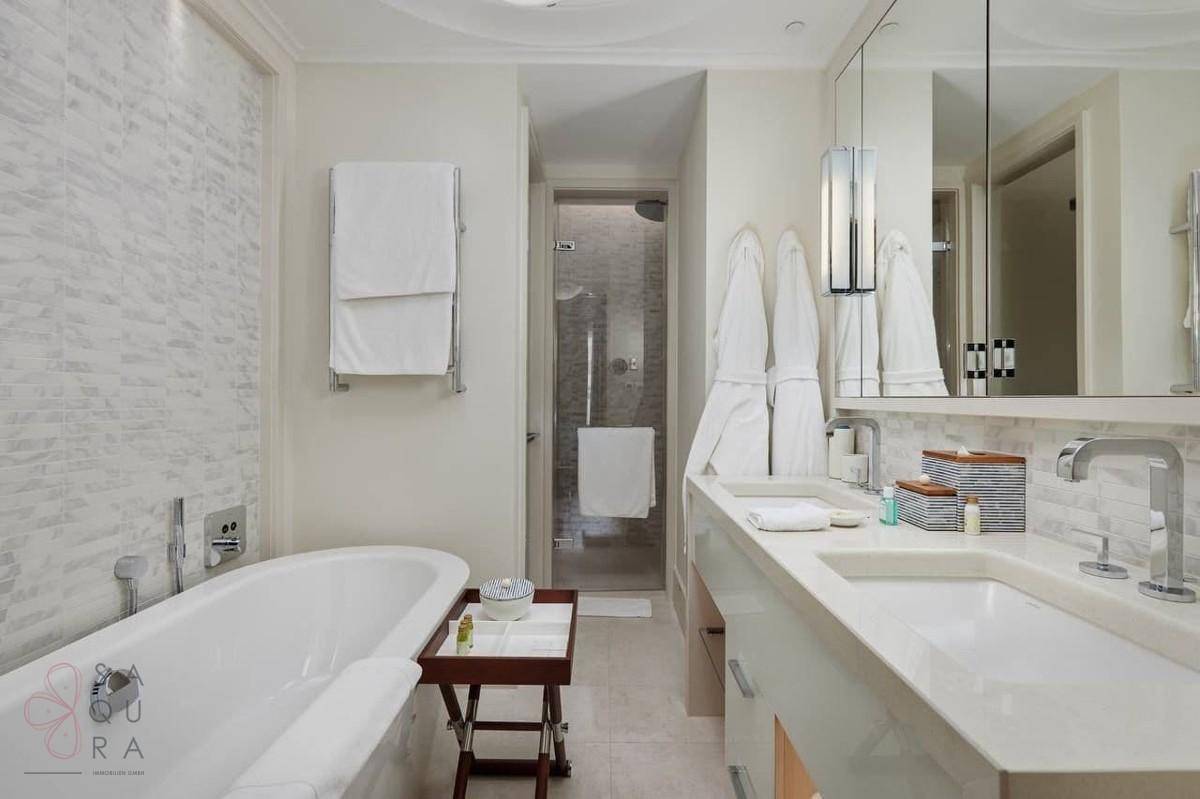 Luxuriöses Badezimmer mit Badewanne, Doppelwaschbecken und separater Duschkabine.