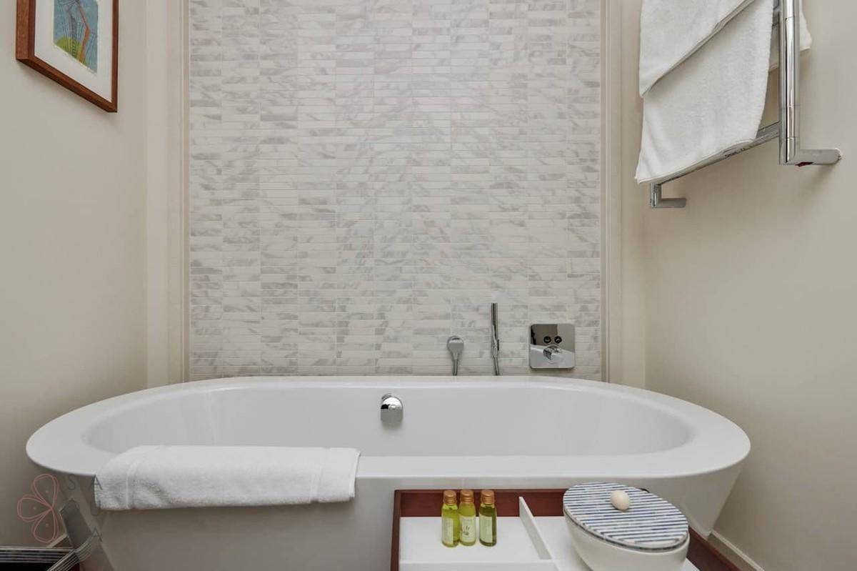 Elegante Badewanne in einem modernen Badezimmer mit strukturierten Wandfliesen.