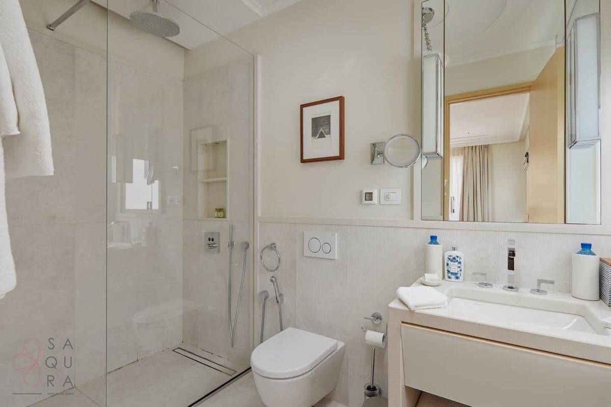 Modernes Badezimmer mit bodengleicher Dusche, Wand-WC und elegantem Waschbecken.