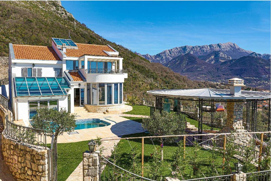 Weitläufiger Gartenbereich mit Villa, Pool und einem Pavillon, umgeben von einer beeindruckenden Berglandschaft.