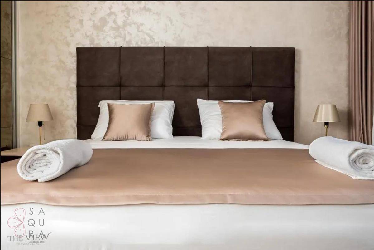 Gemütliches Schlafzimmer mit Doppelbett, Nachttischen und warmen Farbtönen, die eine entspannte Atmosphäre schaffen.
