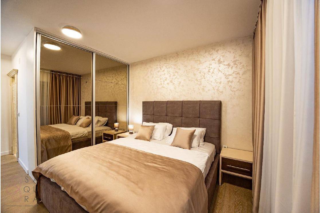 Schlafzimmer mit Doppelbett und großen Spiegelschränken, die den Raum optisch vergrößern.