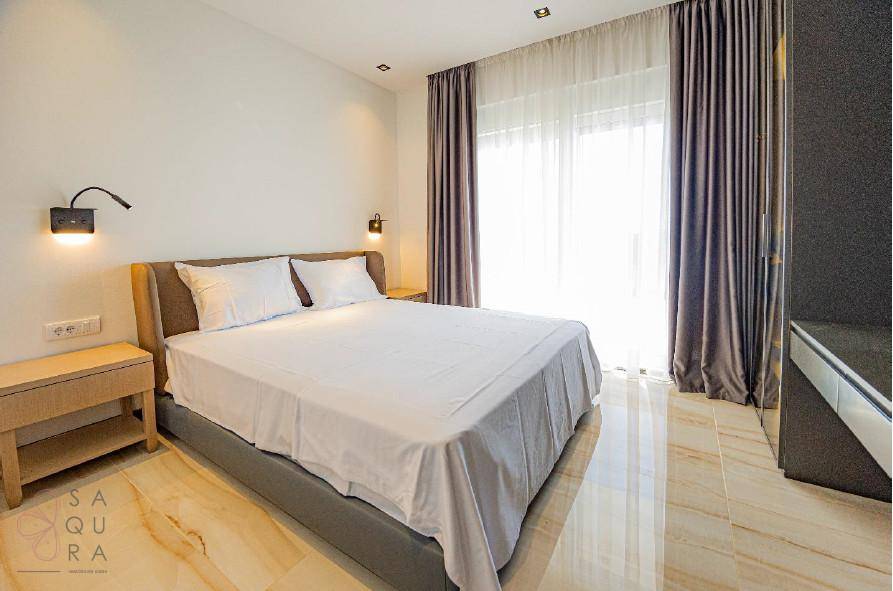 Modernes Schlafzimmer mit großem Bett, Nachttischen und viel natürlichem Licht.