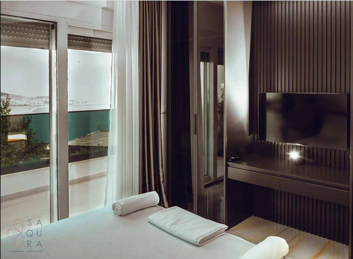 Schlafzimmer mit Balkonzugang, Meerblick und modernen Möbeln.