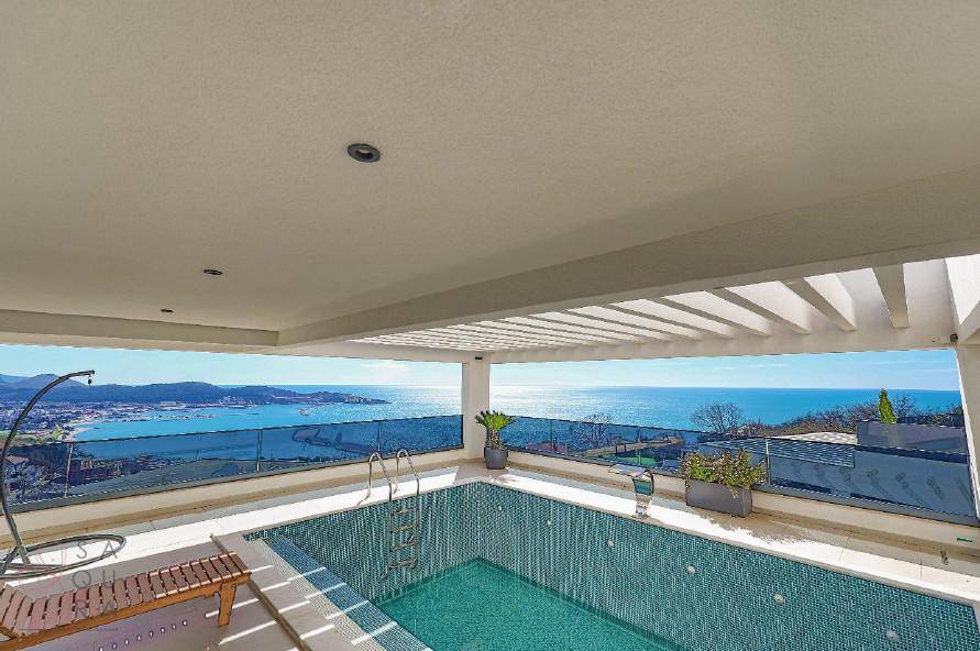 Weitläufiger Poolbereich mit Meerblick, Pergola und viel Platz zum Entspannen.
