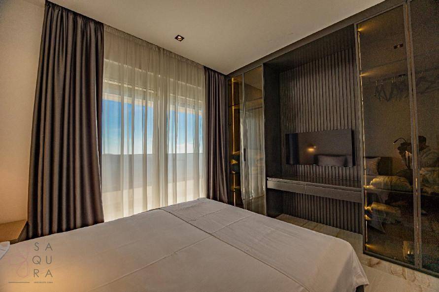 Schlafzimmer mit integriertem Kleiderschrank, Fernseher und weitem Ausblick.
