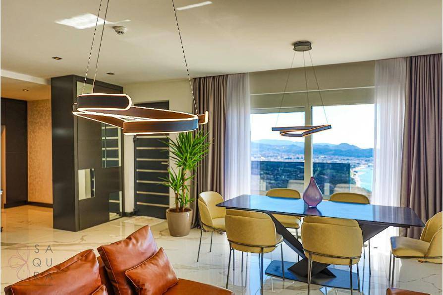 Eleganter Essbereich mit modernem Tisch, gelben Stühlen und weitem Blick auf die Stadt und das Meer.
