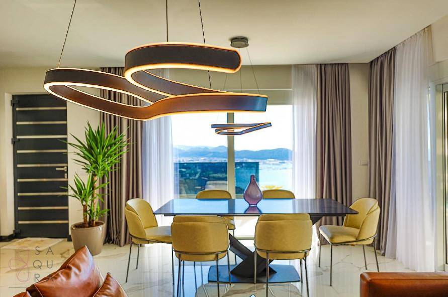 Stilvoller Essbereich mit modernem Design, großen Fenstern und Panoramablick auf die Küste.