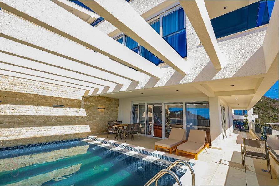 Entspannender Poolbereich mit Liegestühlen, Esstisch und Pergola, ideal für sonnige Tage.